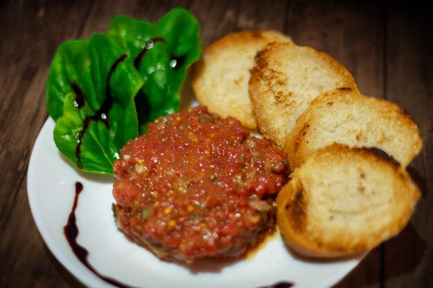 Cerca de tartar de carne y picatostes