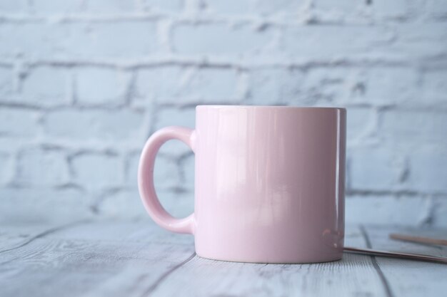 Cerca de la taza de café de color rosa en la mesa