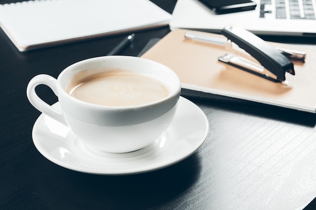 Cerca de una taza de café en el interior de la mesa de oficina