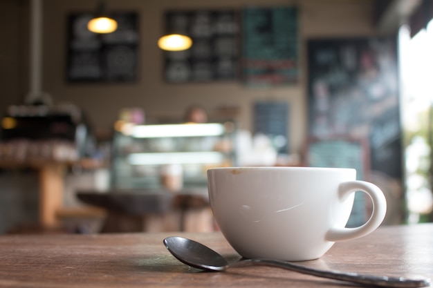 Cerca de taza de café latte arte caliente en la mesa de madera