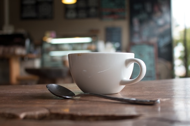 Foto cerca de taza de café latte arte caliente en la mesa de madera