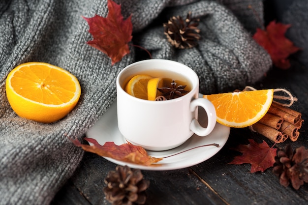 Cerca de una taza de té con naranja y canela