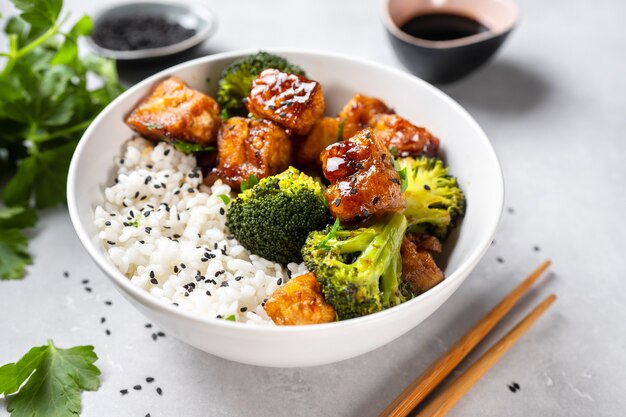 Cerca del tazón de tofu con arroz y brócoli