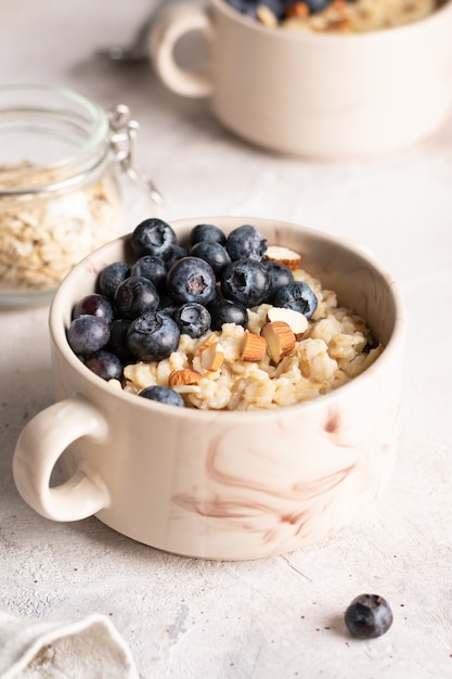 Cerca de tazones de fuente con gachas de avena con arándanos para el desayuno