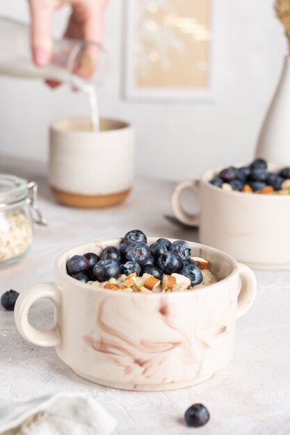 Cerca de tazones de fuente con gachas de avena con arándanos para el desayuno