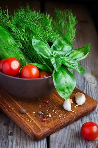 Cerca de tomates cherry, pepinos, eneldo y albahaca