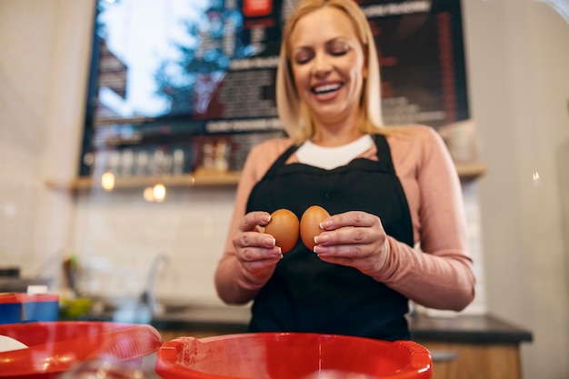 Cerca de un trabajador de la casa de panqueques rompiendo huevos para hacer una mezcla de crepes