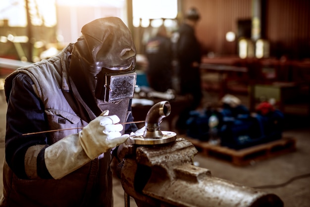 Cerca de un trabajador de sexo masculino en uniforme protector trabajando en nuevas piezas de la máquina.