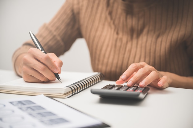 Foto cerca del trabajo manual de personas con calculadora para negocios y finanzas.