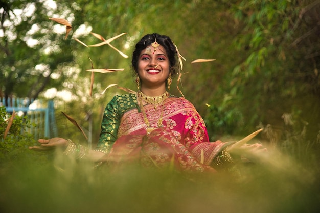 Cerca de la tradicional india hermosa joven en sari posando al aire libre en el parque