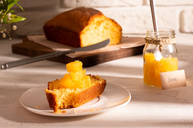 Cerca de un trozo de tarta de naranja con mermelada