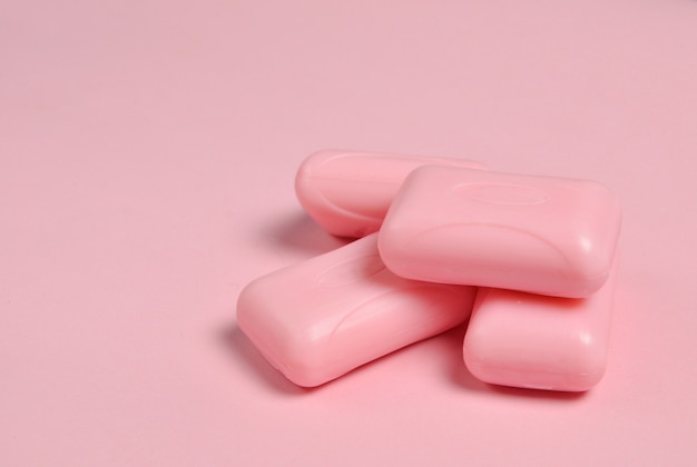 Cerca de trozos de jabón sobre un fondo rosa pastel
