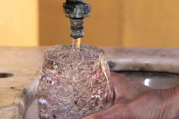 Cerca del vaso de agua derramado mano de mujer