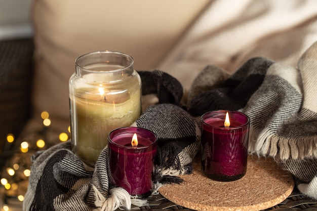 Cerca de velas encendidas en candelabros con detalles de comodidad en el hogar.