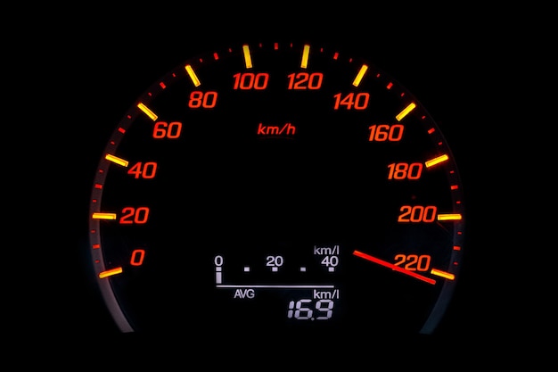 Foto cerca del velocímetro del coche con la aguja apuntando a una alta velocidad en el fondo