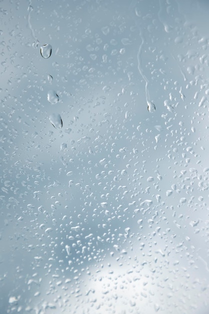 Foto cerca de una ventana con gotas de lluvia vista vertical