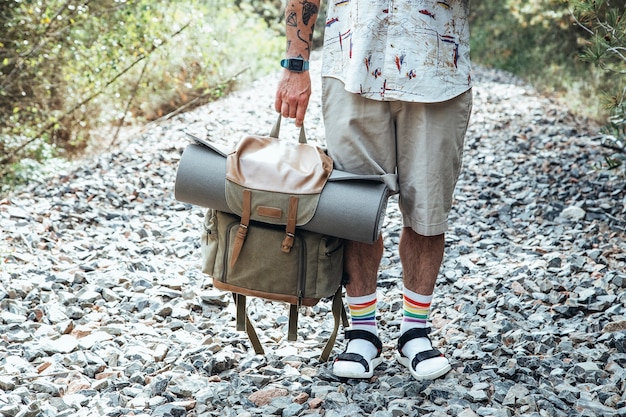 Cerca de viajero hombre sosteniendo una mochila en medio de la carretera para perder