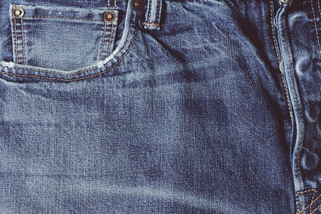 Cerca de viejos pantalones vaqueros de mezclilla, fondo de color clásico