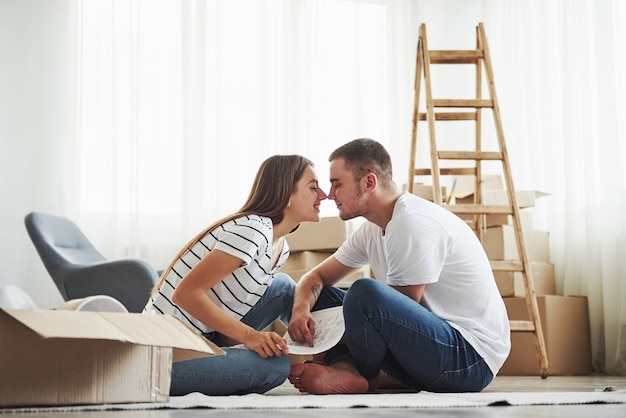 Cercanía de la gente. Pareja joven alegre en su nuevo apartamento. Concepción de mudanza.