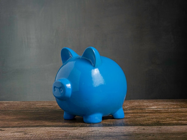 Cerdito azul en la mesa de madera para ganar o ahorrar concepto