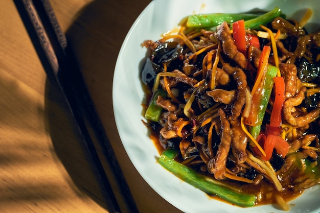 Cerdo agridulce con verduras al wok en un cuenco blanco. Cocina china.