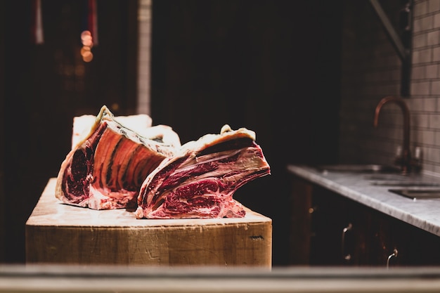 El cerdo crudo fresco rasga en la tabla de madera en la carnicería que muestra en ventana.