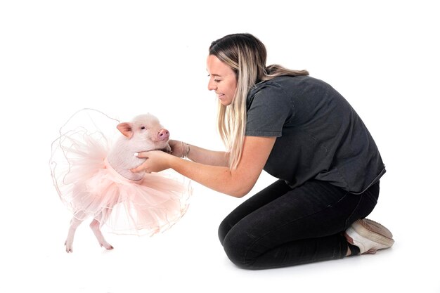 cerdo en miniatura rosa y mujer frente a un fondo blanco