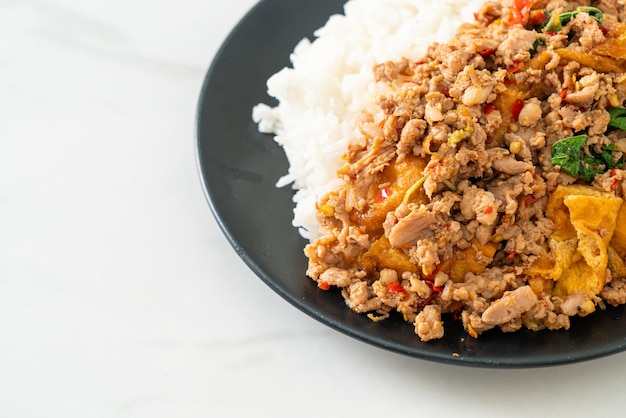 cerdo picado salteado con albahaca y huevo cubierto con arroz - estilo de comida asiática