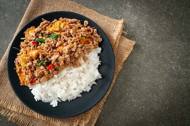 cerdo picado salteado con albahaca y huevo cubierto con arroz - estilo de comida asiática