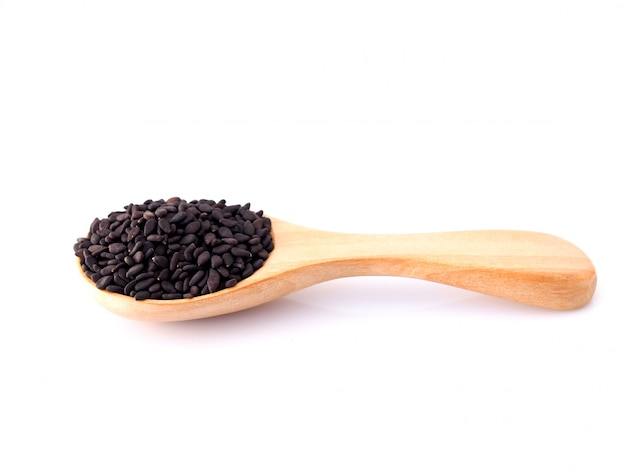 Cereal alimentos secos granos enteros con semillas de sésamo negro cuchara de madera. Aislado en superficie blanca.