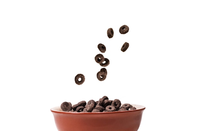 El cereal con anillos de chocolate se derrama en un bol Desayuno
