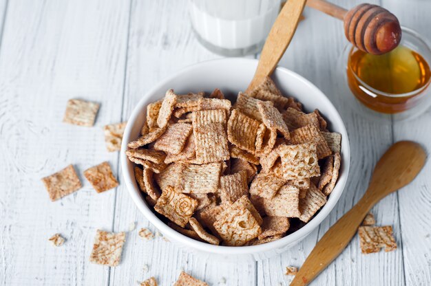 Cereal de café da manhã e um vidro do leite fresco.