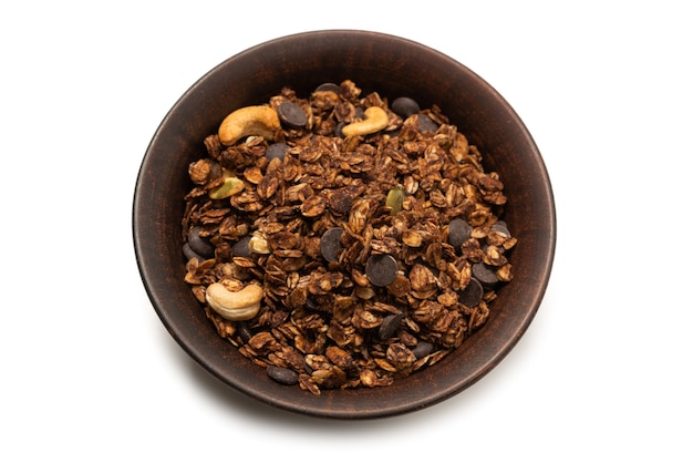 Cereal de granola de chocolate com nozes em uma superfície de tigela