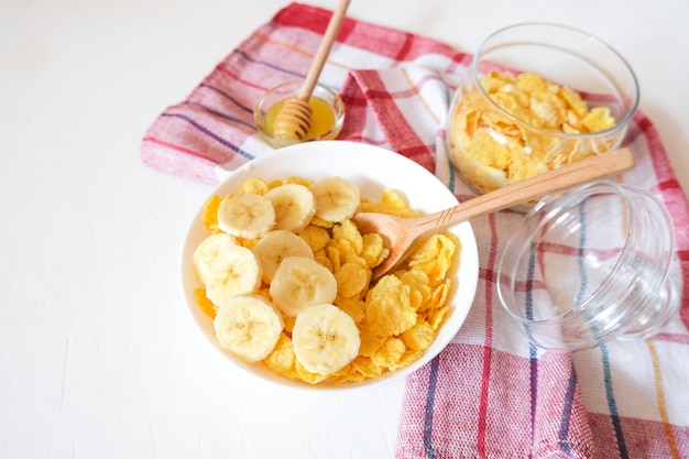 Cereal de pequeno-almoço tradicional de cereais e leite com uma banana