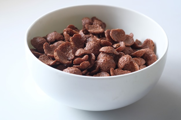 Cereal de desayuno de chocolate en un recipiente blanco sobre la mesa.