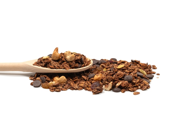 Cereal de granola de chocolate con nueces en una cuchara de madera