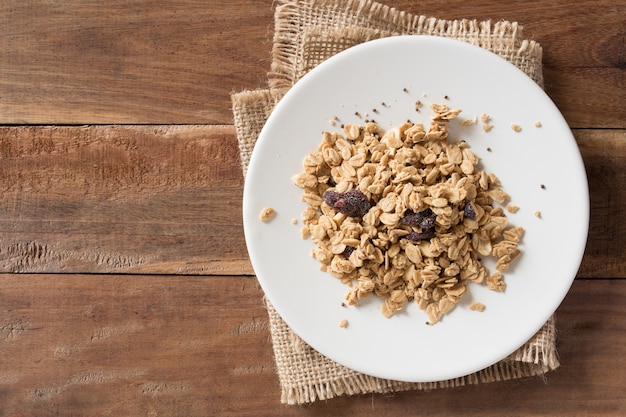 Cereal en plato blanco sobre fondo de madera.