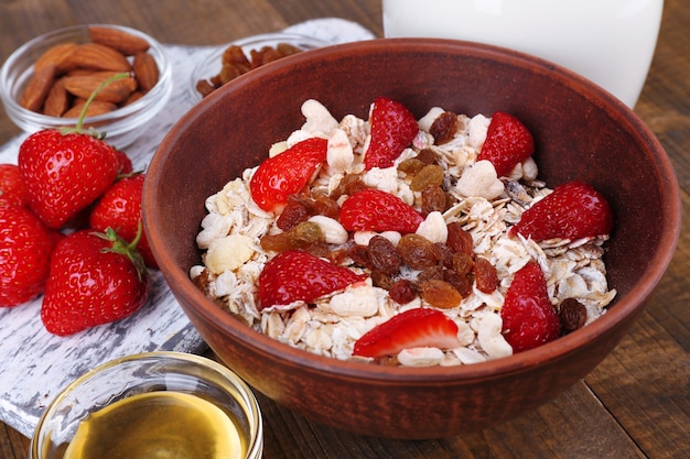 Cereal saludable con leche y fresa en mesa de madera