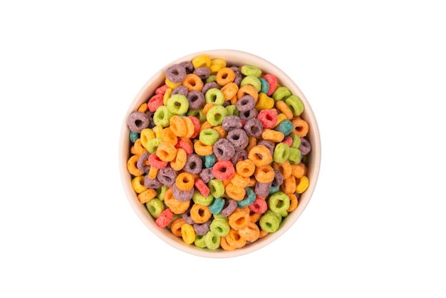 Los cereales de anillos de colores se derraman en un cuenco. Desayuno. Aislado en un fondo blanco.