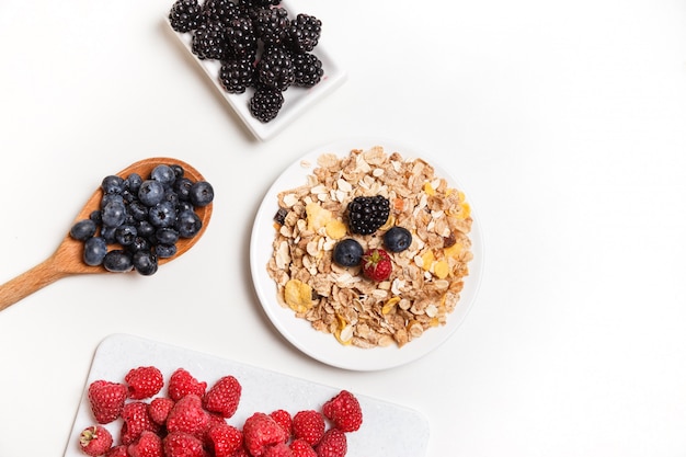 Cereales con bayas frescas aisladas en blanco