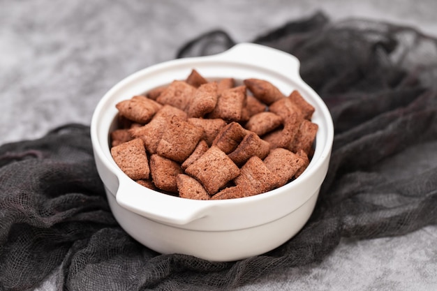 Cereales de chocolate en un pequeño tazón blanco sobre cerámica