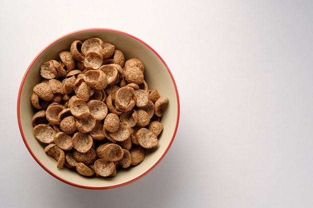 Cereales desayuno sabor a cacao en un tazón sobre fondo de madera con espacio de copia