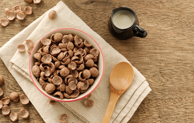 Cereales desayuno sabor a cacao en un tazón sobre fondo de madera con espacio de copia