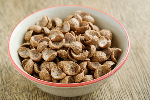 Cereales desayuno sabor a cacao en un tazón sobre fondo de madera