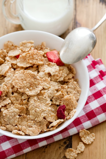 Cereales con frutos secos en un tazón blanco y leche