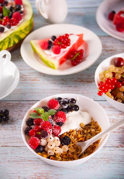 Cereales granola muesli con yogur o leche y bayas frescas Concepto de desayuno saludable