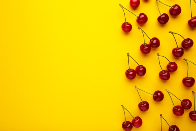 Foto cereja doce em fundo amarelo vista superior postura plana