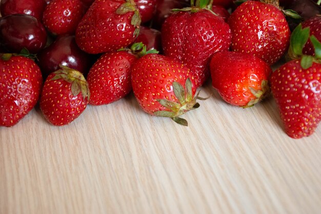 Cereja e morango em uma madeira branca