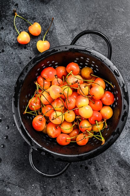 Cerejas amarelas maduras em uma peneira.