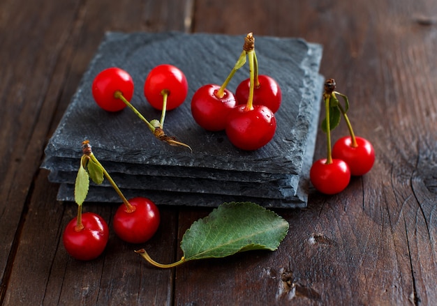 Cerejas frescas em tigelas sobre uma mesa de madeira